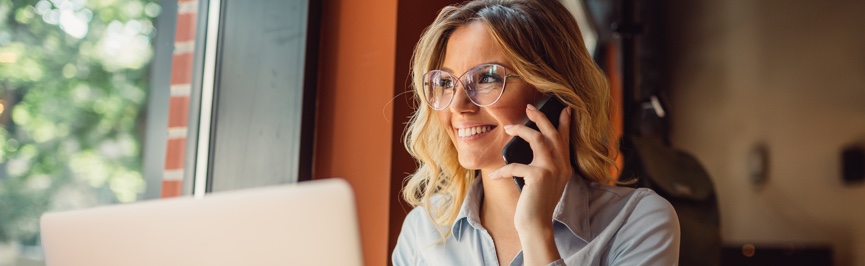 Woman on phone looking at her computer