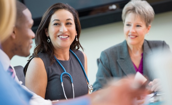 Men and women medical professionals talking around a table
